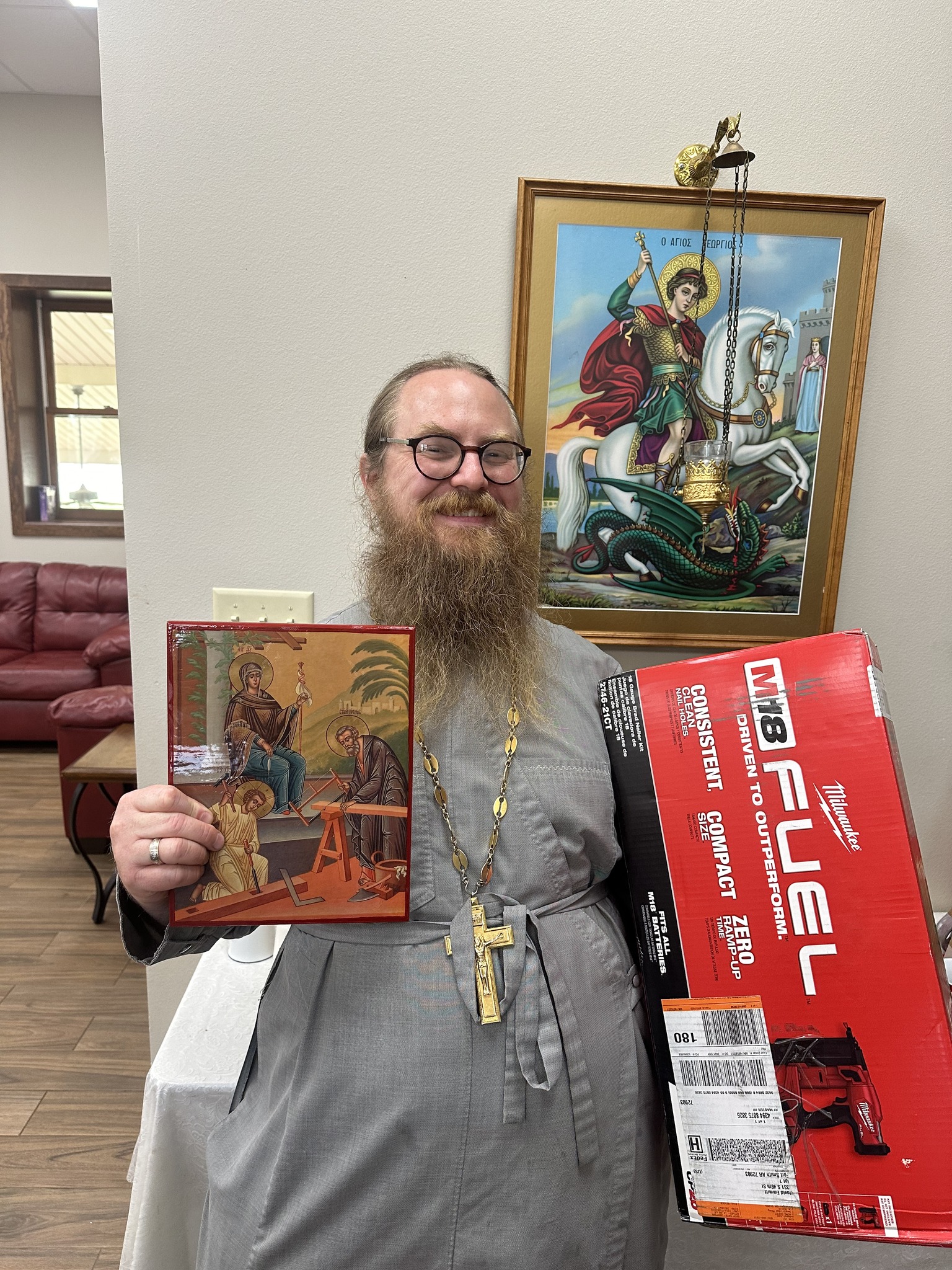 Fr. Alexis Baldwin holding gifts from the church for his birthday.